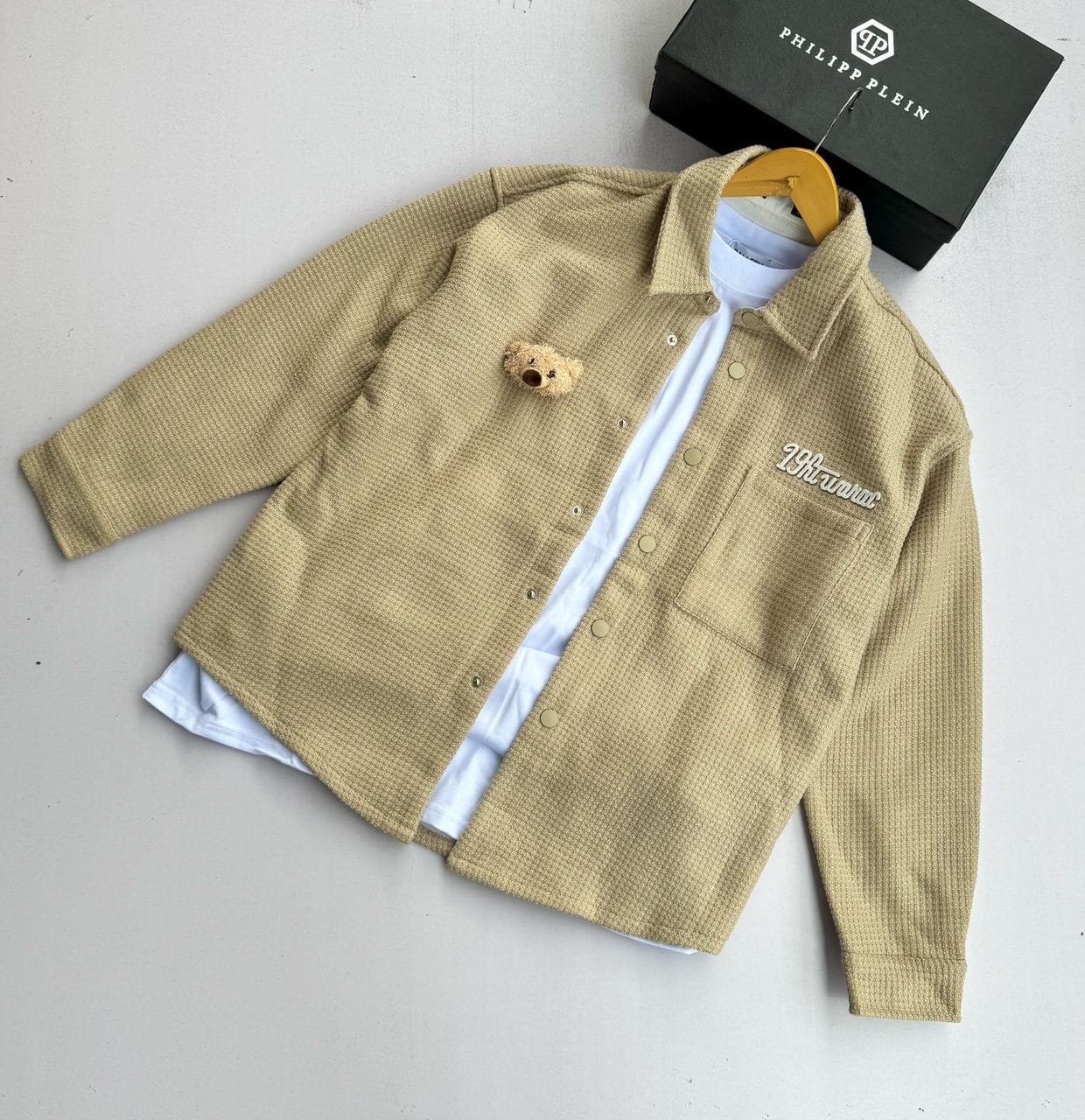 beige, long-sleeved button-down shirt.