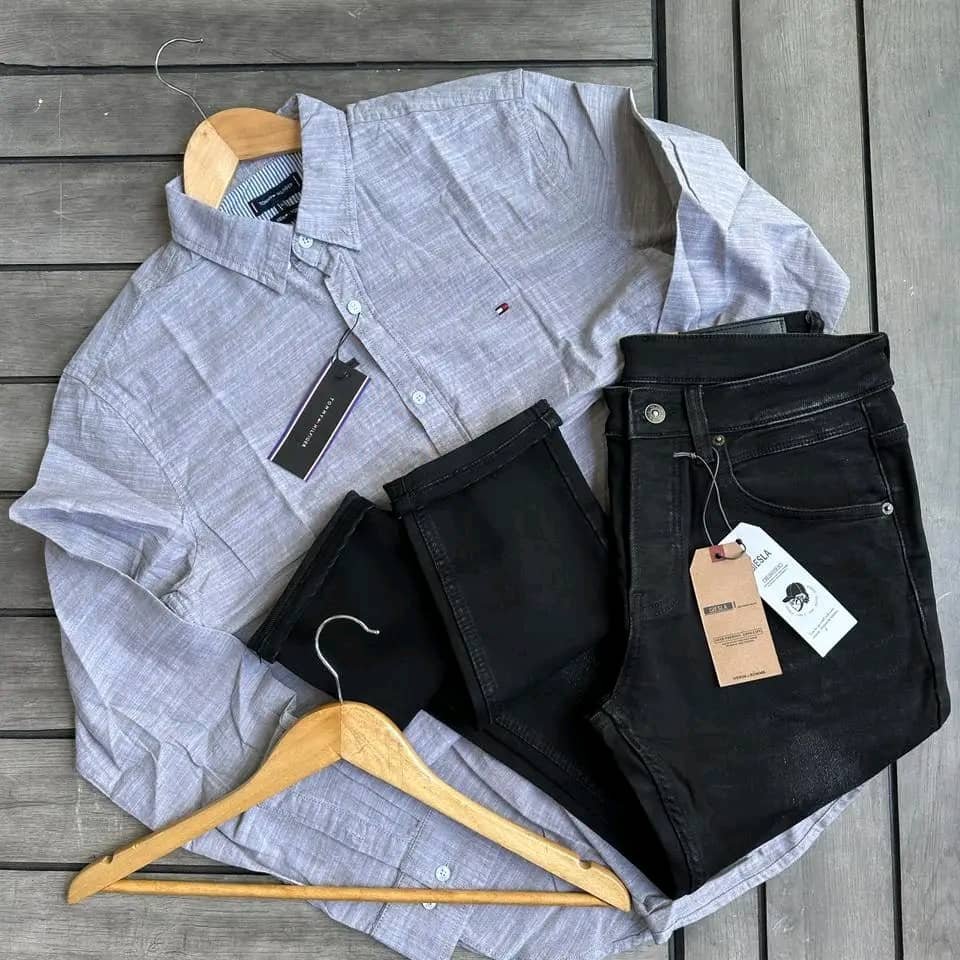 light gray, long-sleeved button-down shirt and a pair of black jeans.