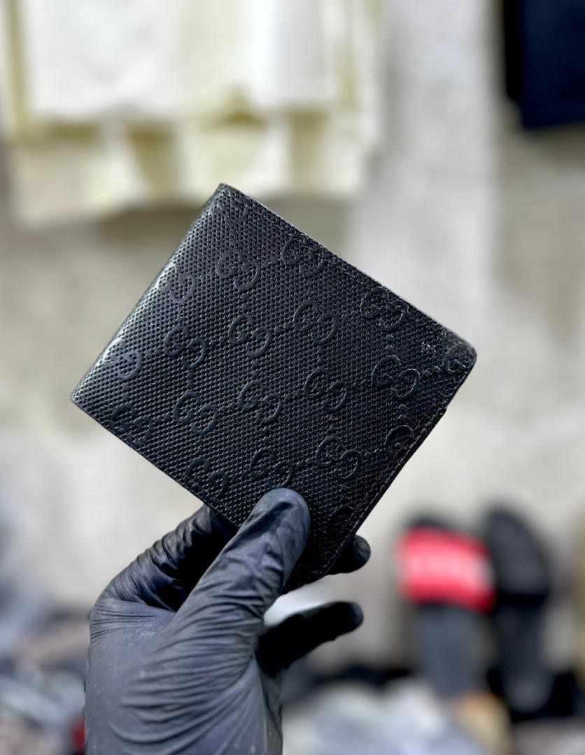 a black Gucci bi-fold wallet
