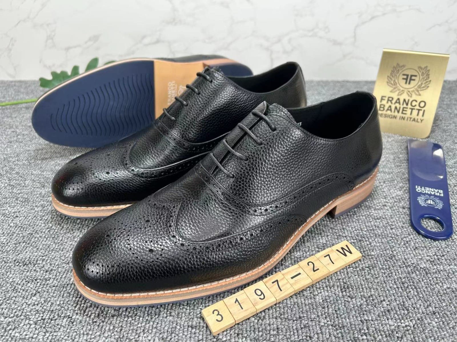 pair of black leather wingtip shoes