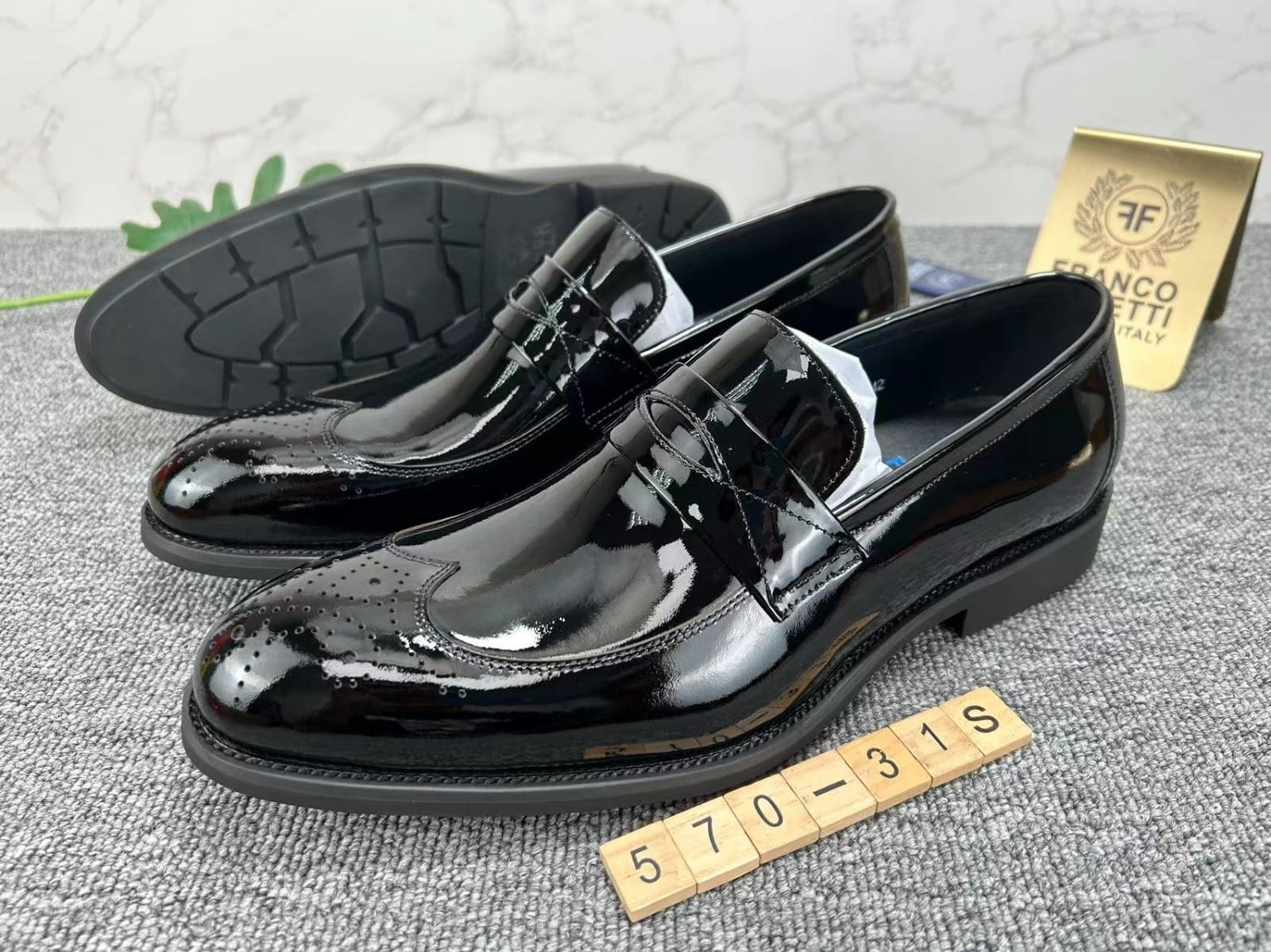 pair of black leather wingtip shoes