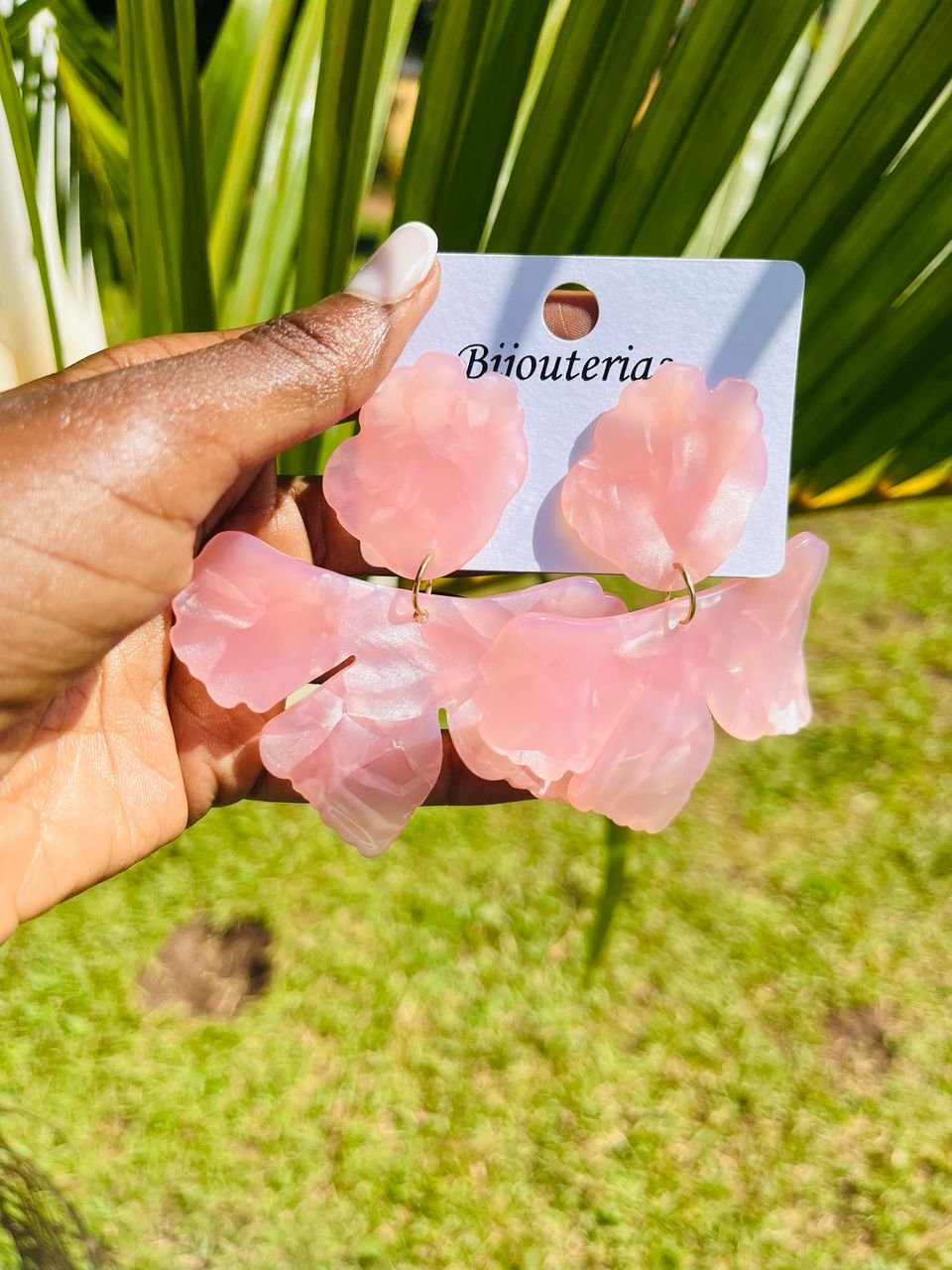 a pair of pink, petal-shaped dangle earrings.