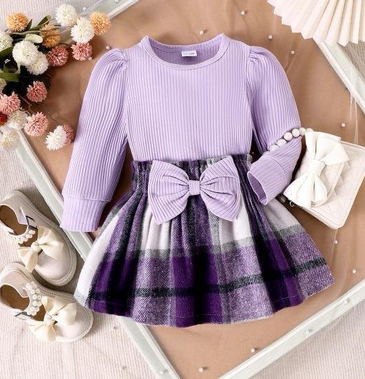 purple long-sleeved dress with a plaid skirt and a large bow detail